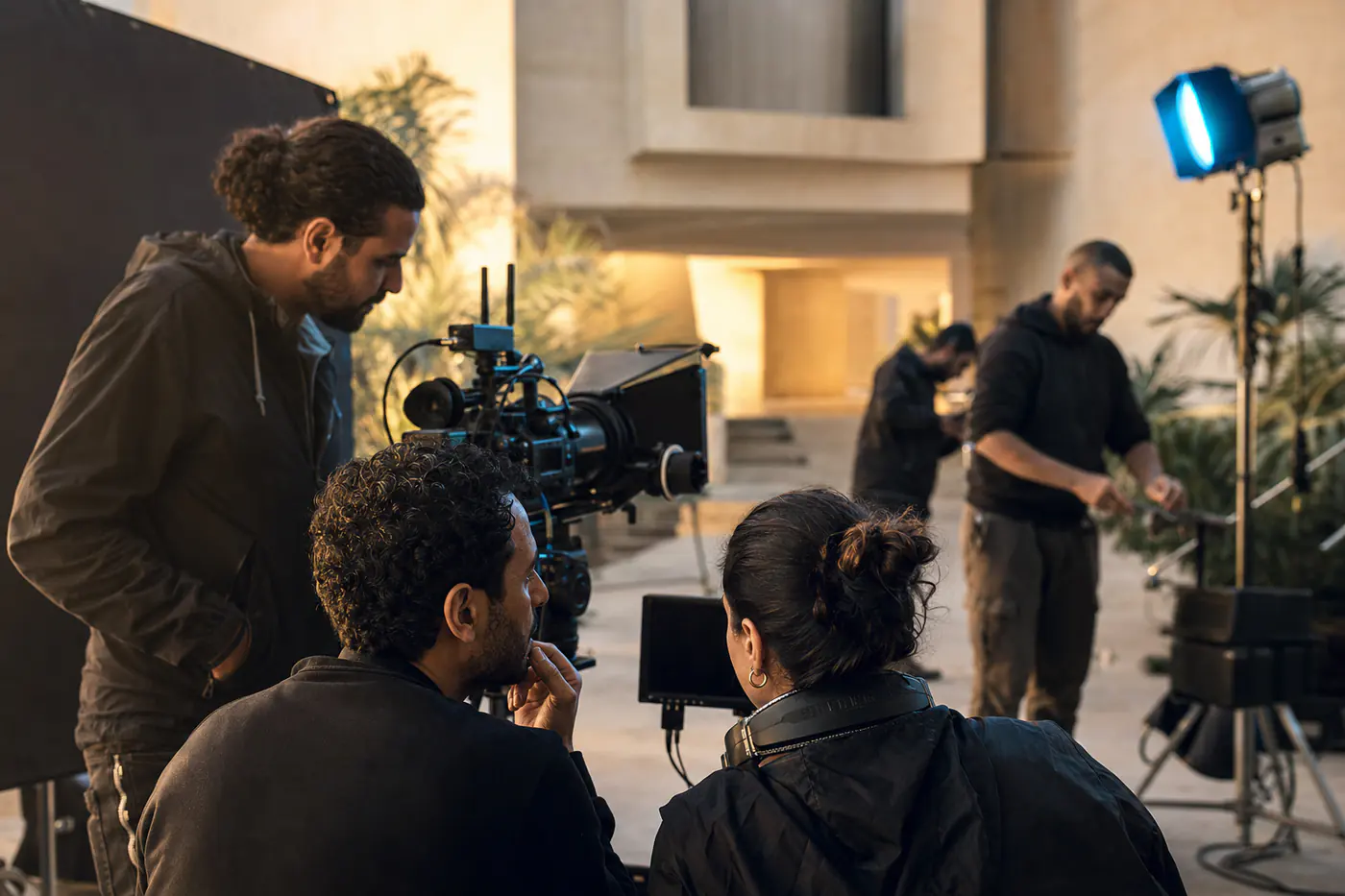 Une équipe de production prépare un tournage autour d’une caméra de cinéma.
